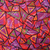 Close-up of red fabric with purple, green and yellow geometric all-over print