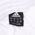 Adidas waistband tag on white track pants showing size L