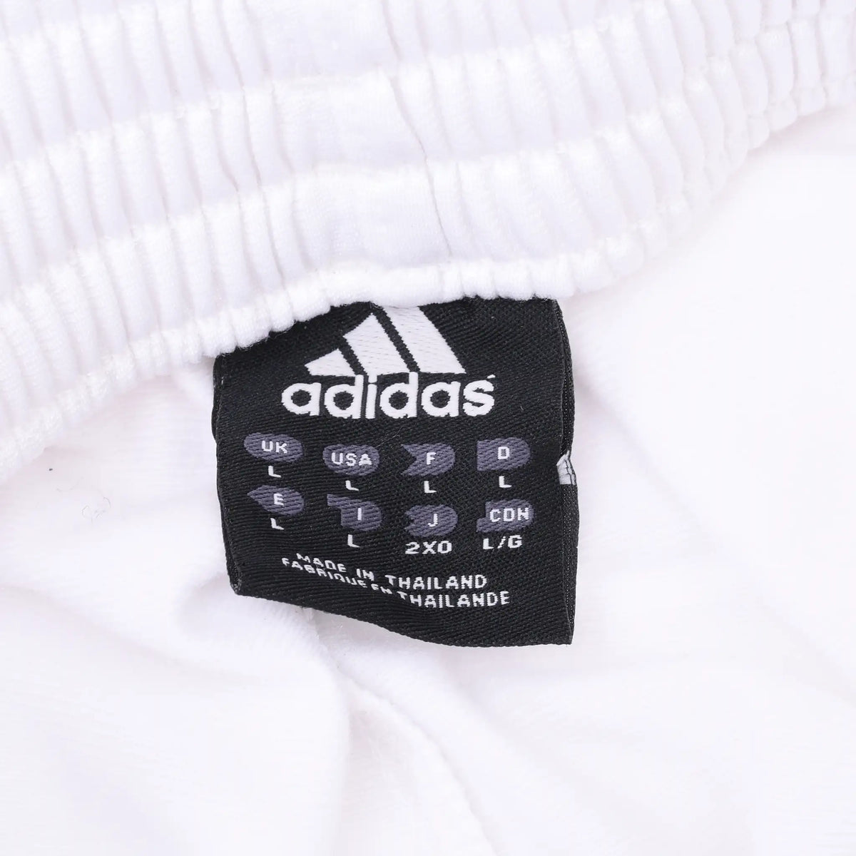 Adidas waistband tag on white track pants showing size L