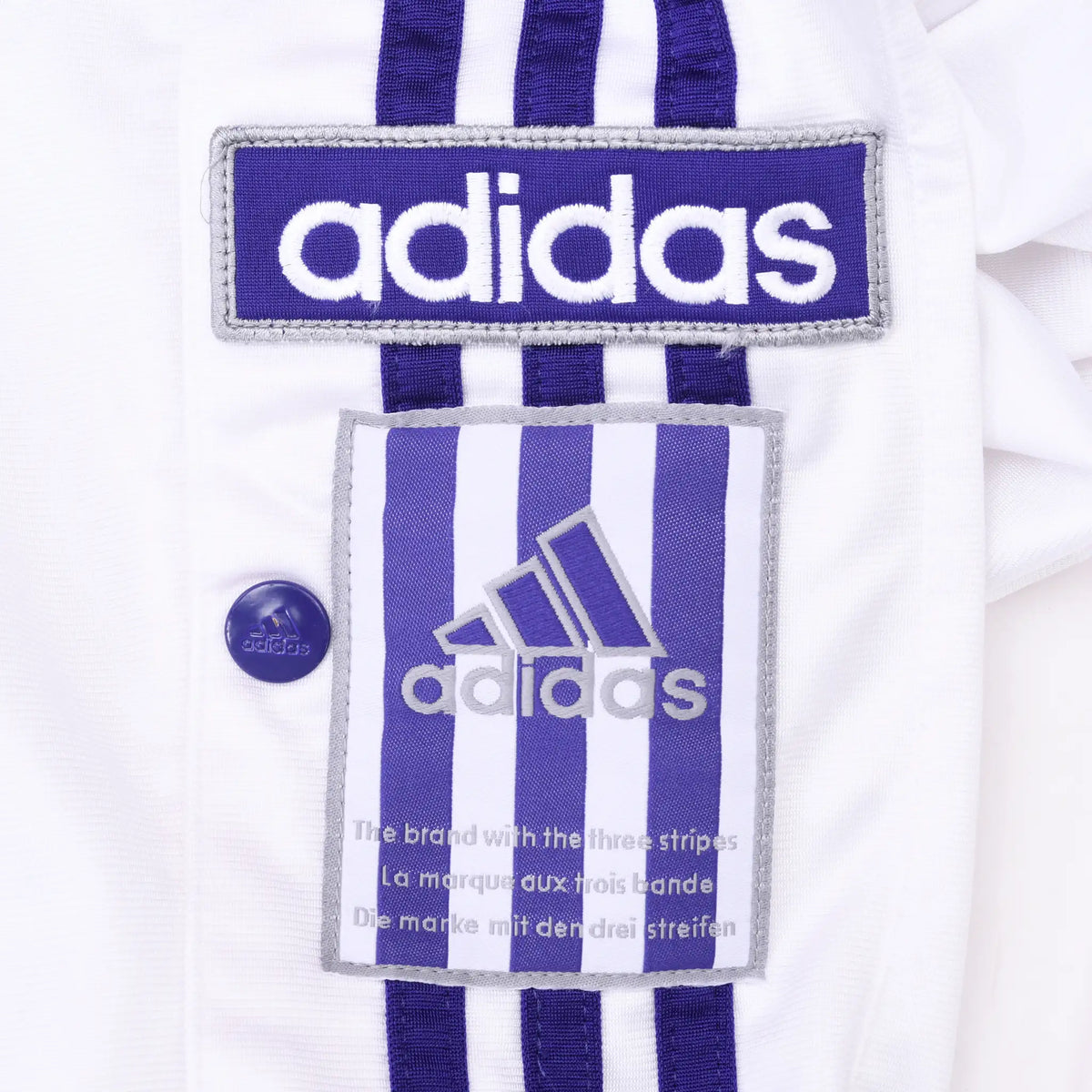 Adidas patches, purple three-stripe trim, and branded side snap button detail