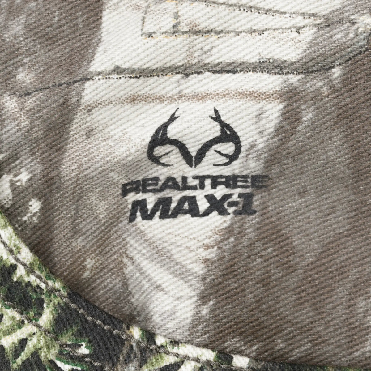 Close-up of Realtree Max-1 antler logo printed on camouflage fabric
