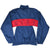 Back of navy Nike windbreaker jacket with outlined NIKE lettering across a red stripe and white panels