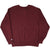 Back of burgundy Champion crewneck sweatshirt with small logo patch near the lower left hem
