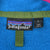 Close-up of Patagonia neck label, large size tag, and Made in USA tag on blue fleece