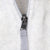 Close-up of gray zipper pull and webbing tab on beige fleece