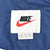 Nike neck label with black logo, red Swoosh, XL size marking, and Made in Thailand text