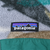 Close-up of Patagonia logo patch above the teal chest pocket