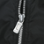 Close-up of silver front zipper and Nike Swoosh pull on black fabric