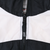 Close-up of black front zipper and Nike-branded zipper pull on white and black panels