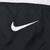 Close-up of white Nike Swoosh embroidery on black fabric