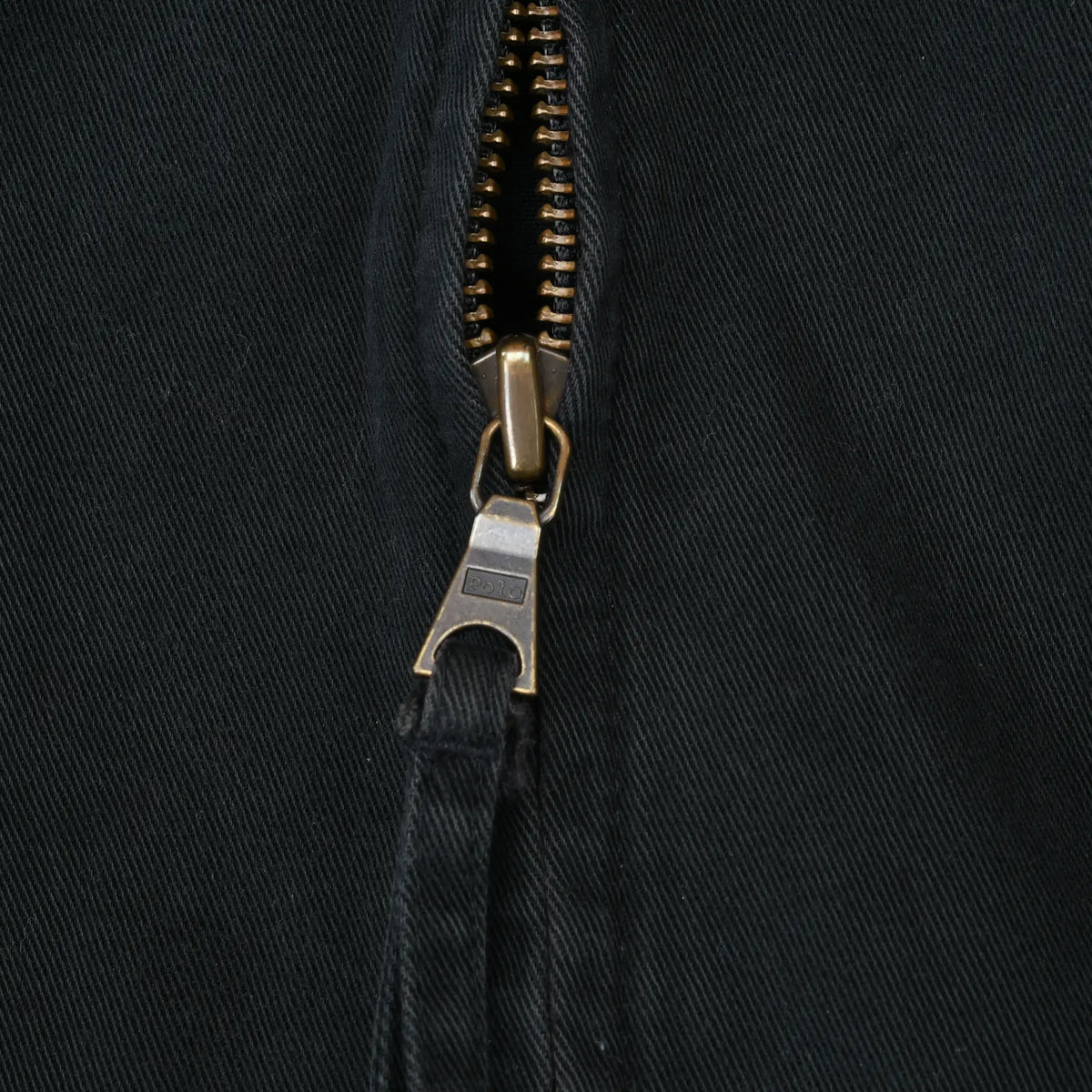 Close-up of metal front zipper and fabric pull on black Polo Ralph Lauren jacket
