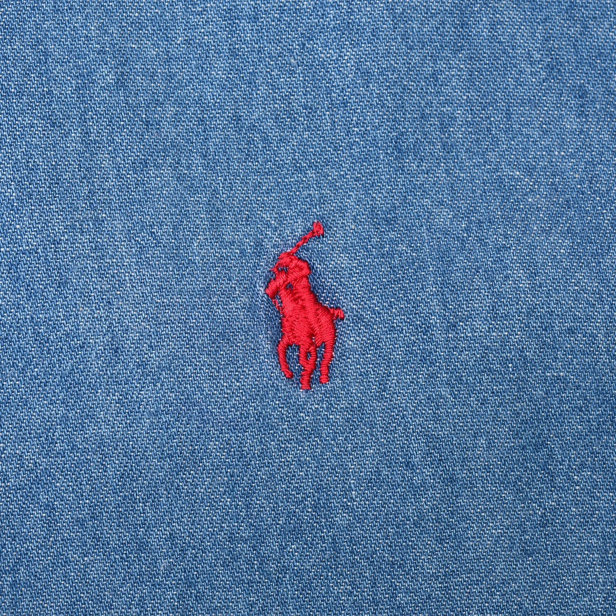 Close-up of red Ralph Lauren polo pony embroidery on blue denim fabric