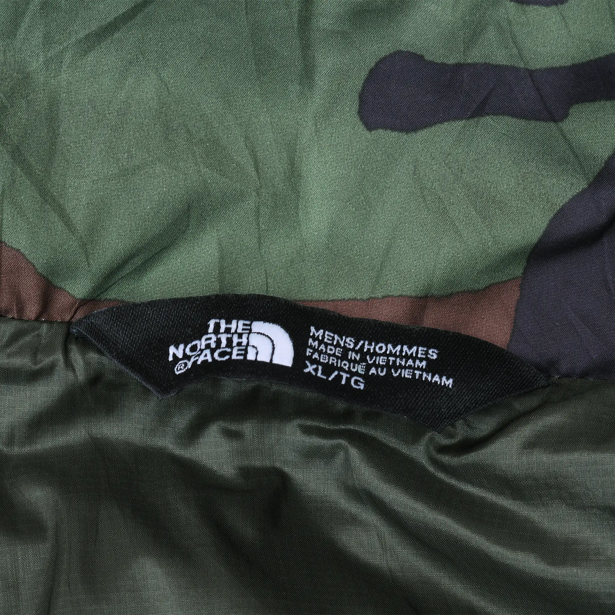 The North Face interior label on camouflage vest marked men's XL and made in Vietnam