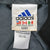 Close-up of Adidas neck label showing medium size and nylon fabric details