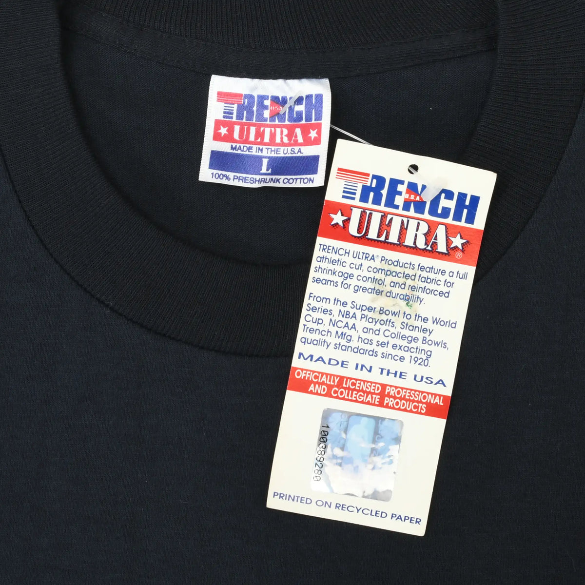 Close-up of Trench Ultra neck label and attached product hang tag on black T-shirt