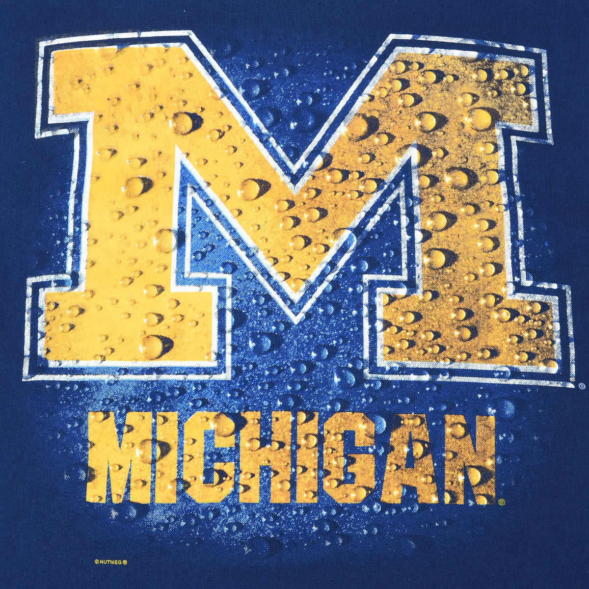 Close-up of maize block M and Michigan water-drop print on navy T-shirt