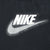 Close-up of white Nike spellout and large Swoosh print on black T-shirt