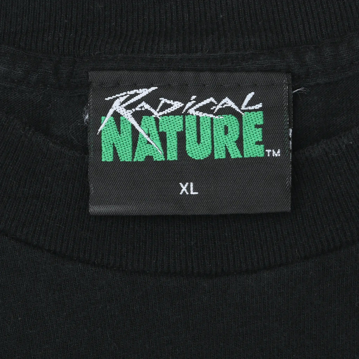 Close-up of Tropical Nature XL neck label on black T-shirt
