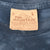 Close-up of The Mountain neck label marked L on blue T-shirt