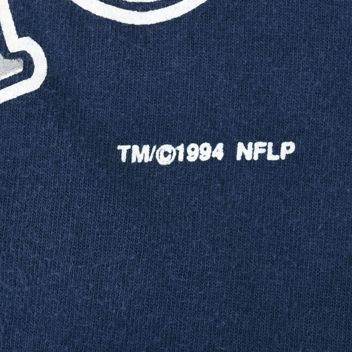 Close-up of TM ©1994 NFLP copyright text printed below the front graphic