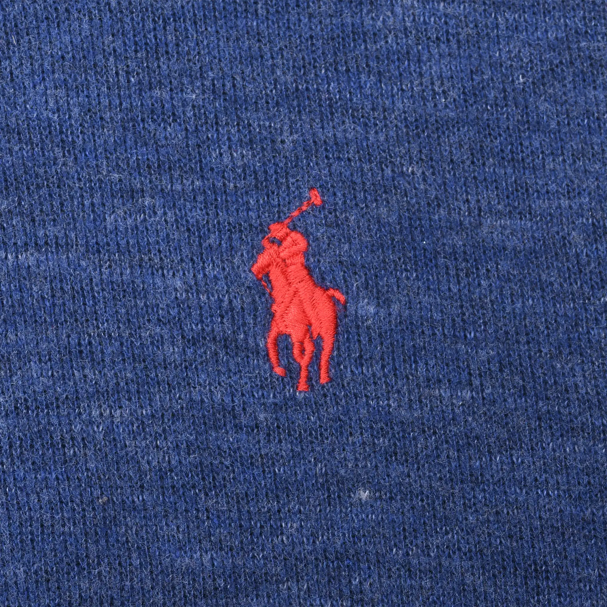 Close-up of red Polo pony embroidery on blue sweater