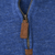 Close-up of quarter-zip closure with brown leather pull on blue sweater