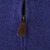 Close-up of quarter-zip closure with brown leather pull on purple sweater