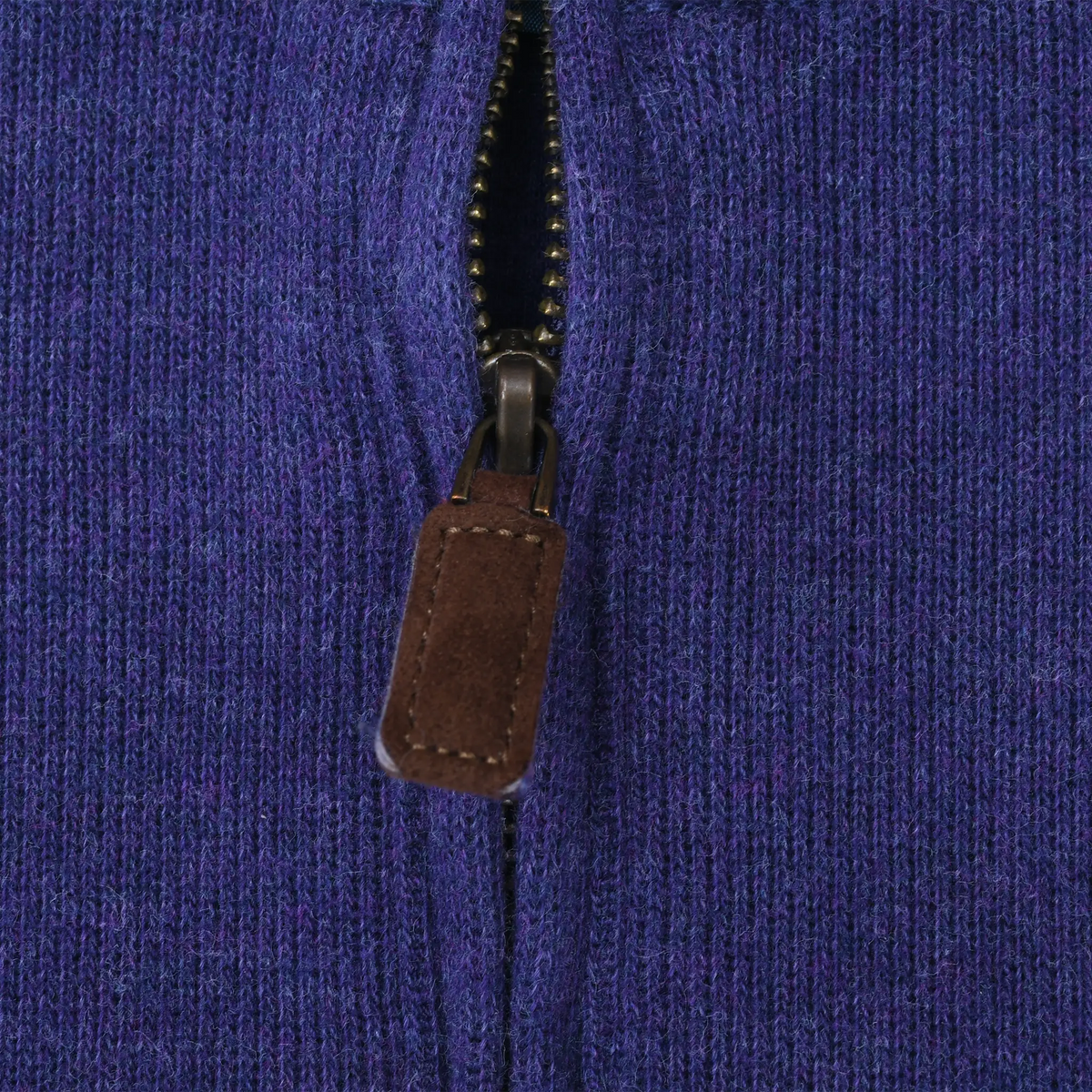 Close-up of quarter-zip closure with brown leather pull on purple sweater