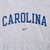 Close-up of blue Carolina chest lettering and Nike Swoosh on grey hoodie