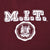 Close-up of white M.I.T. lettering and Massachusetts Institute of Technology seal on burgundy fabric