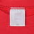 Close-up of neck tag marked 7 and Large inside red sweatshirt