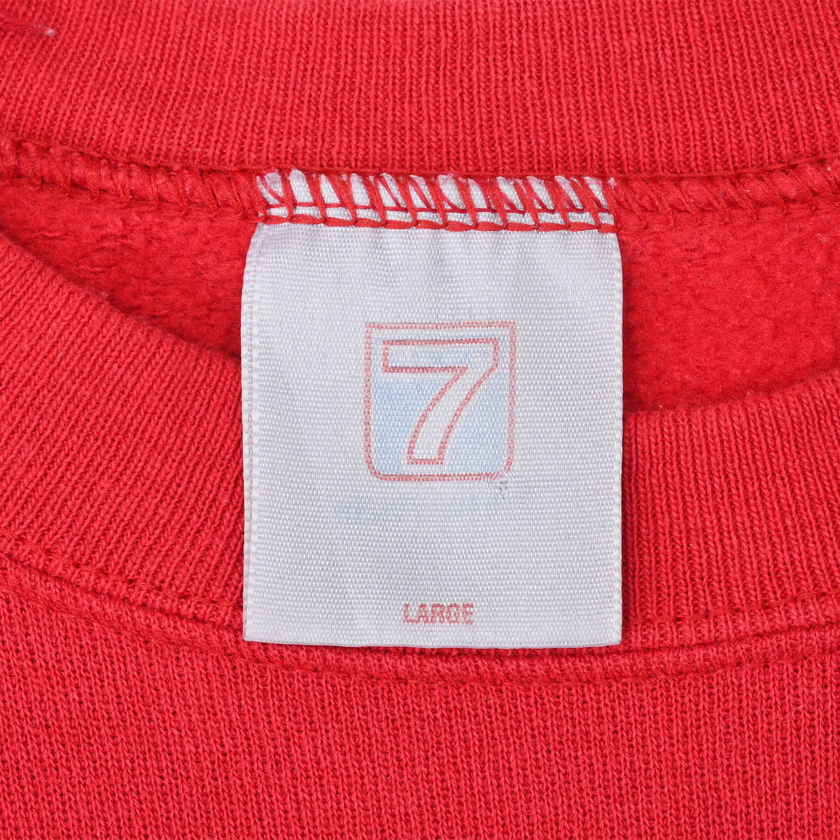 Close-up of neck tag marked 7 and Large inside red sweatshirt