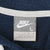 Close-up of gray Nike neck label marked size L inside navy fleece hoodie