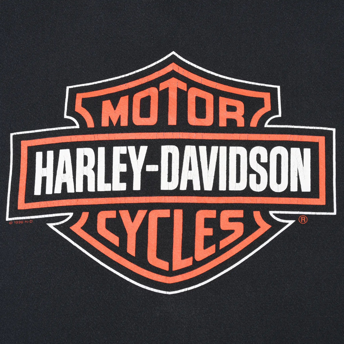 Close-up of orange and white Harley-Davidson bar-and-shield front print
