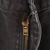 Close-up of brass-tone YKK zipper fly on dark brown Carhartt pants