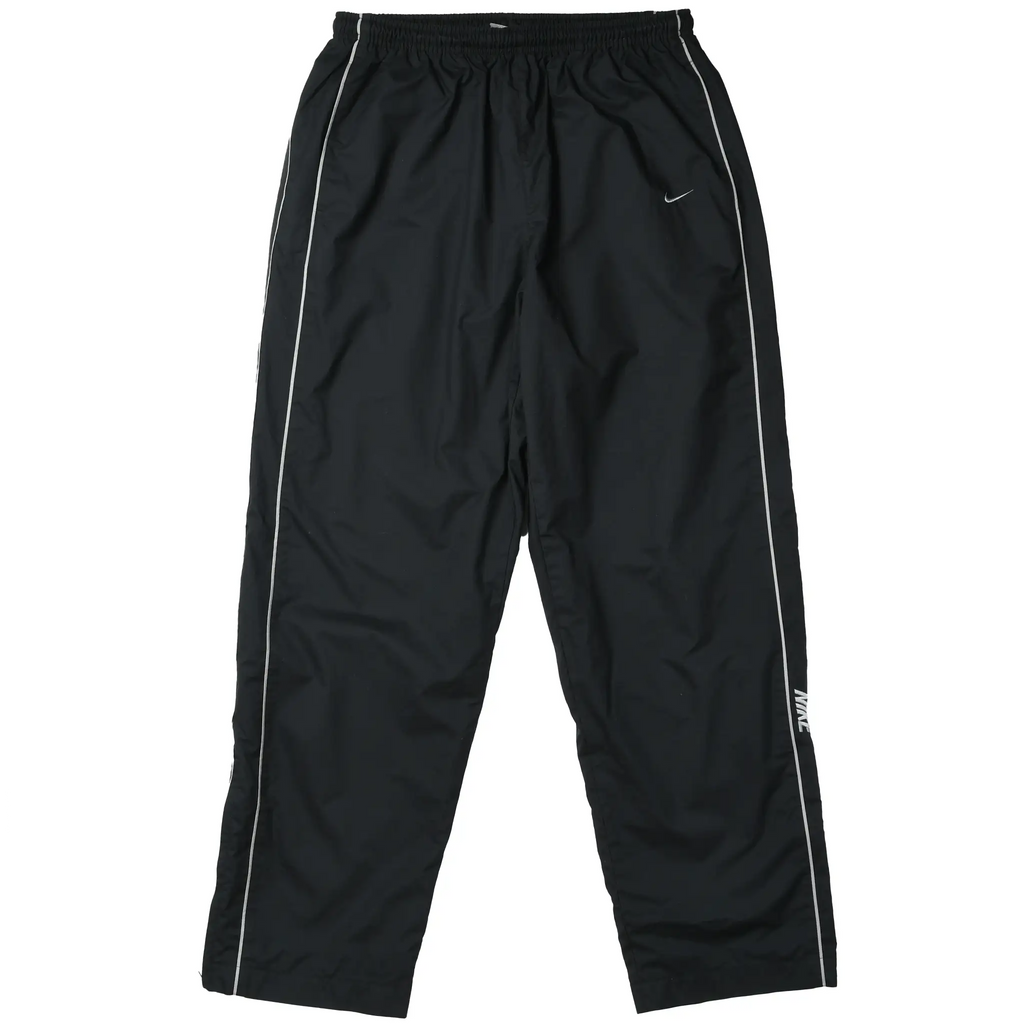Front of black Nike track pants with white piping, Swoosh embroidery, and leg logo