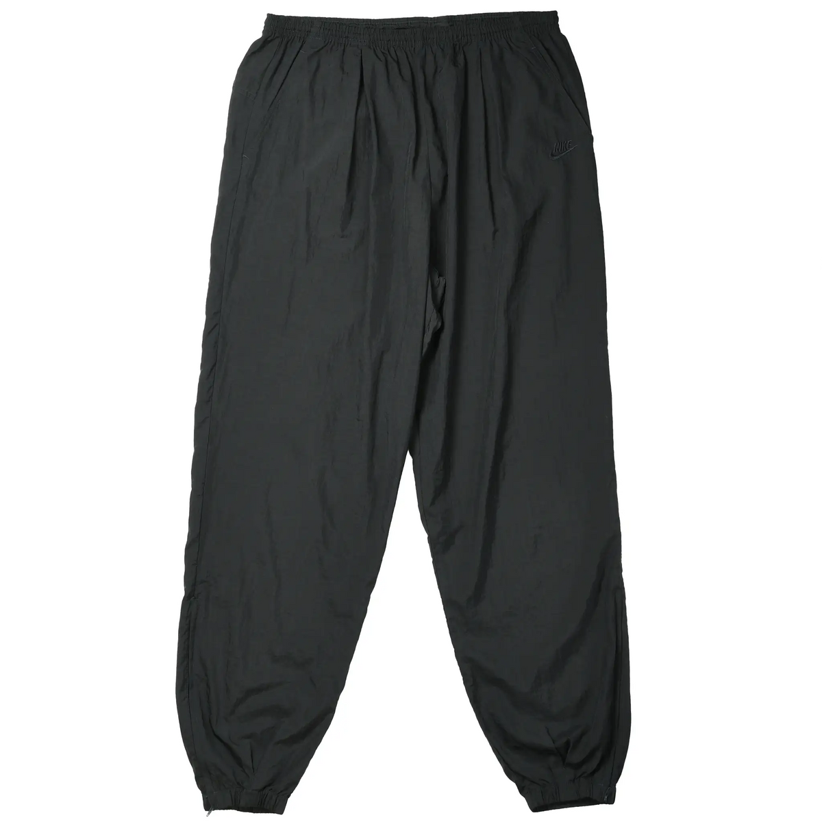 Front of black Nike nylon track pants with elastic waist and cuffs