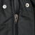Close-up of black Patagonia vest front zipper, metal pull, and snap fasteners