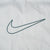 Close-up of large green outlined Nike Swoosh embroidery on light grey fabric