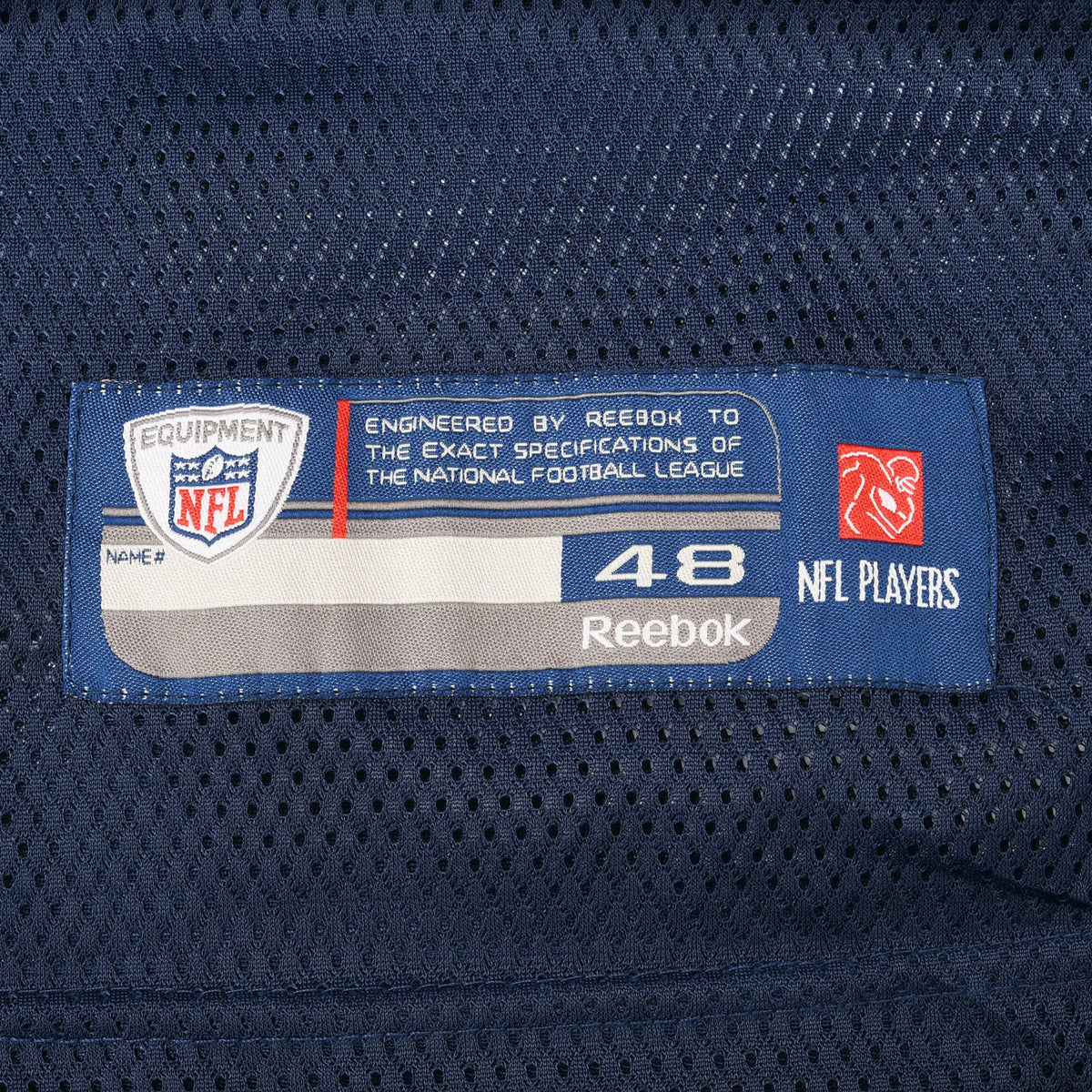 Close-up of Reebok NFL Equipment size 48 label on navy mesh jersey