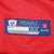 Close-up of Reebok NFL Equipment size 52 hem label on red mesh jersey