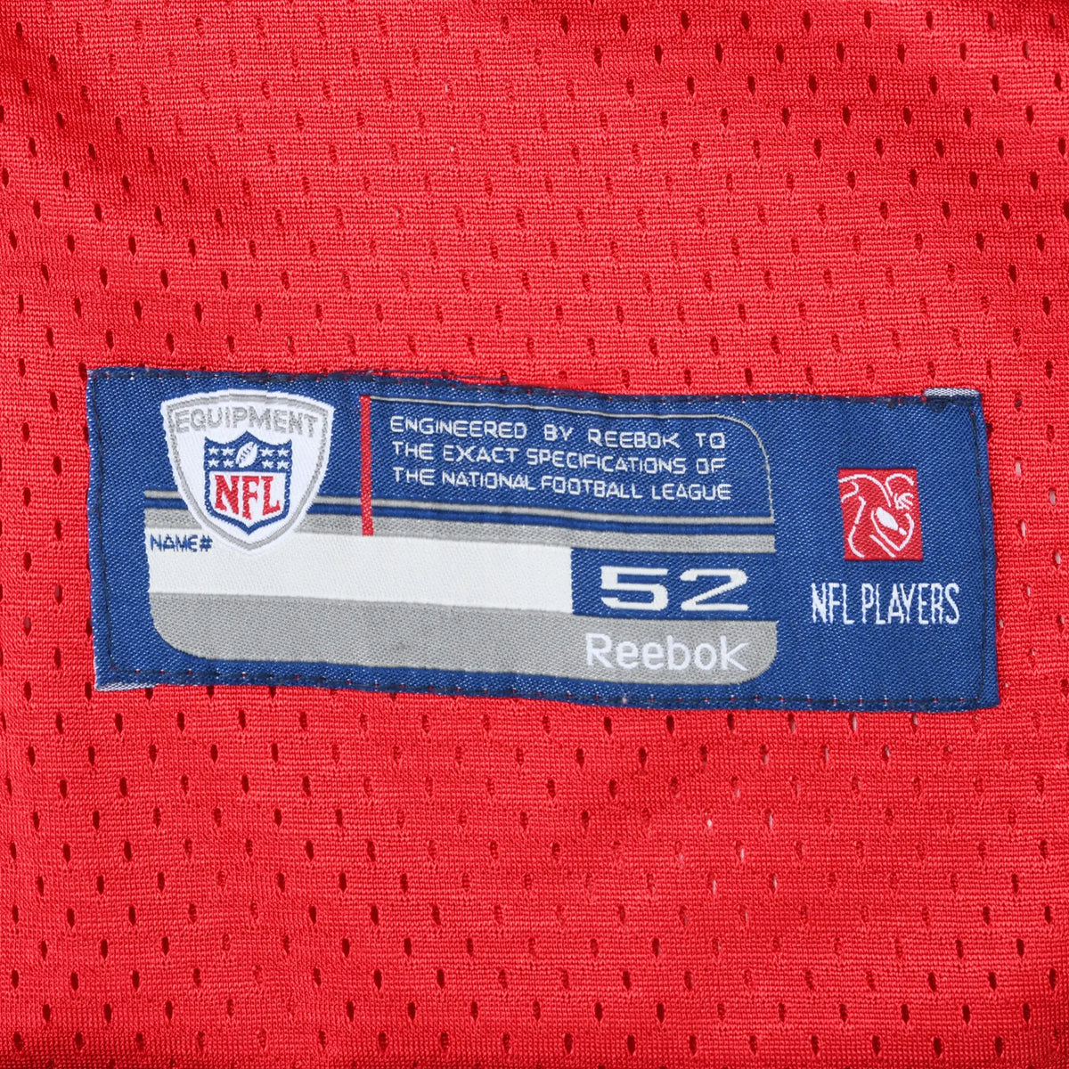 Close-up of Reebok NFL Equipment size 52 hem label on red mesh jersey