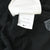 Close-up of white Nike care tag with product codes inside the black jersey