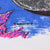Close-up of small copyright text printed over blue water and pink coral in the shirt graphic