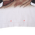 Close-up of white front hem with arrows marking two faint spots below the graphic