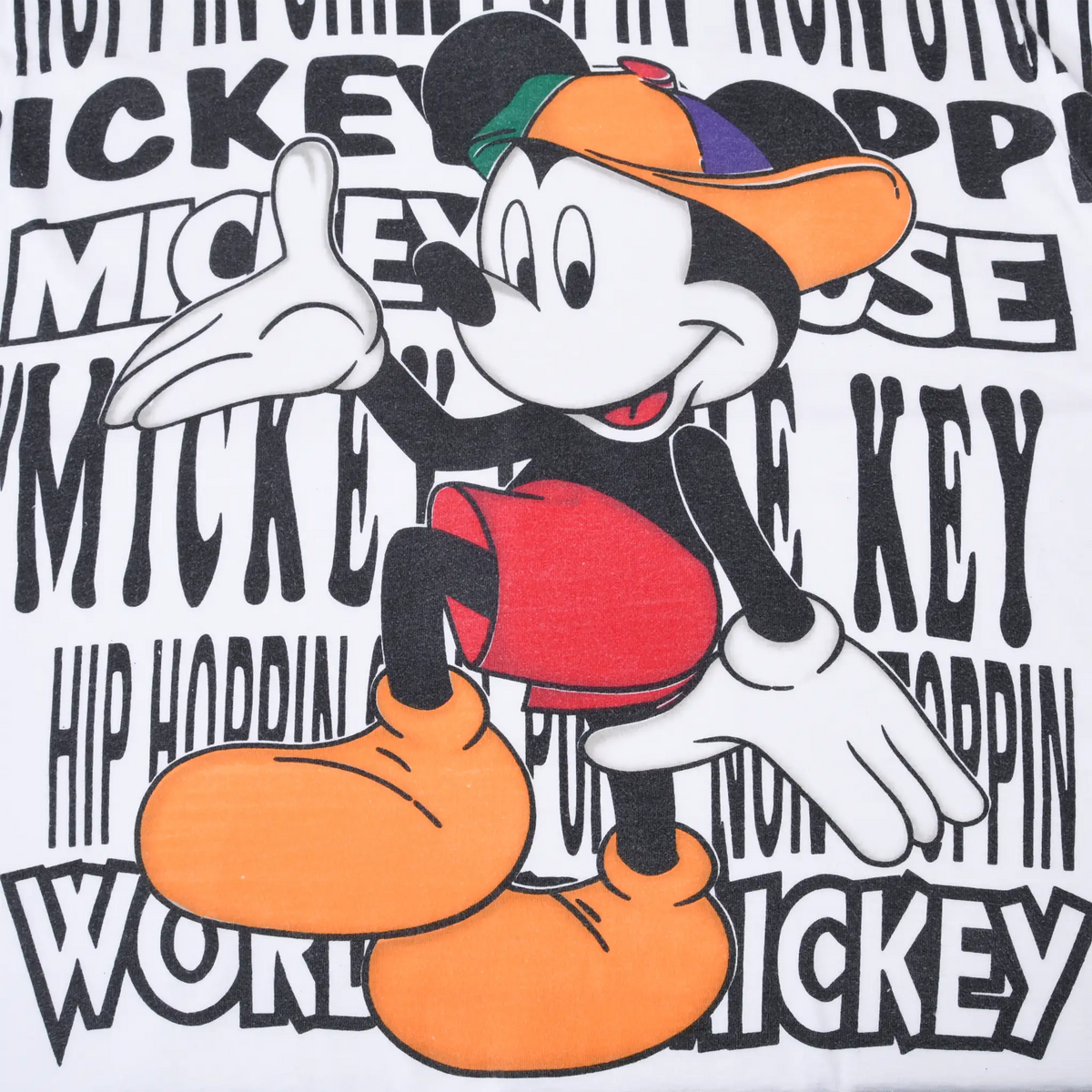 Close-up of Mickey Mouse graphic in colorful cap and orange shoes over black hip-hop text