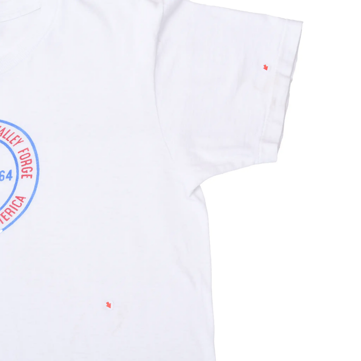 Close-up of white T-shirt right sleeve and torso with red arrows marking small spots