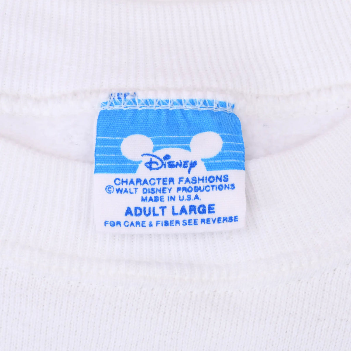 Close-up of blue Disney Character Fashions neck label inside white sweatshirt