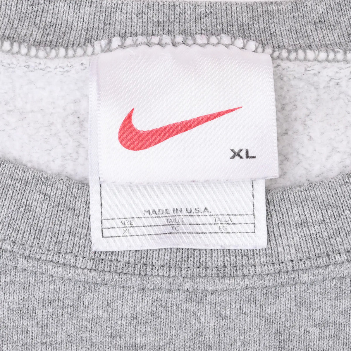 Nike sweatshirt neck tag with red Swoosh, XL marking, and Made in U.S.A. label