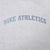 Close-up of blue Nike Athletics lettering and Swoosh on grey sweatshirt